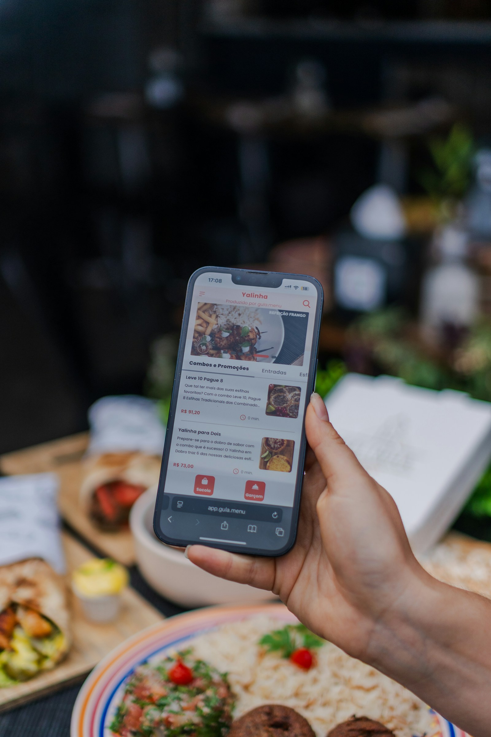 A hand holding a phone showing a food menu